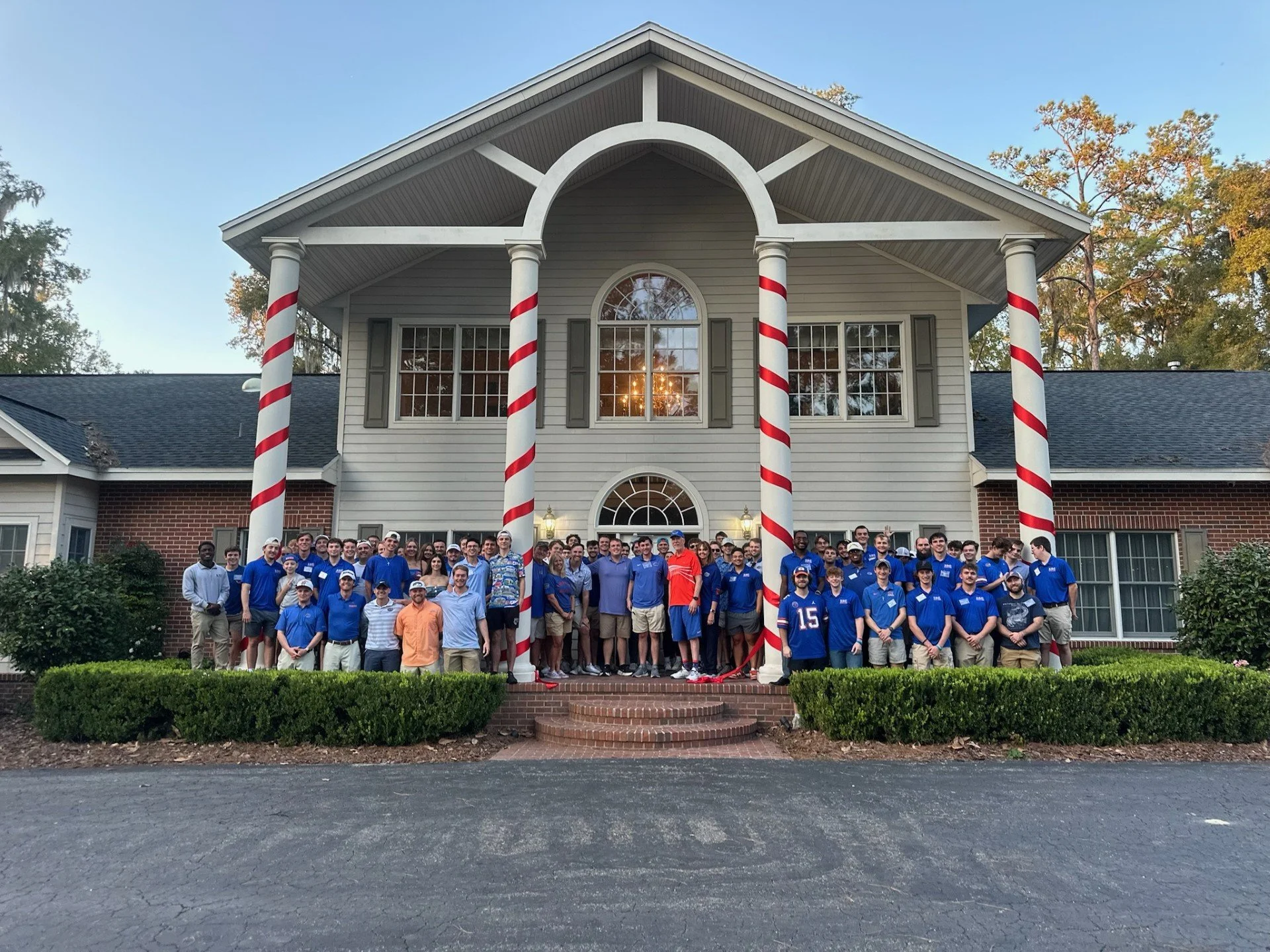 Kappa Phi Epsilon alumni and brothers gathered in front of the new fraternity house for its 2025 ribbon cutting
