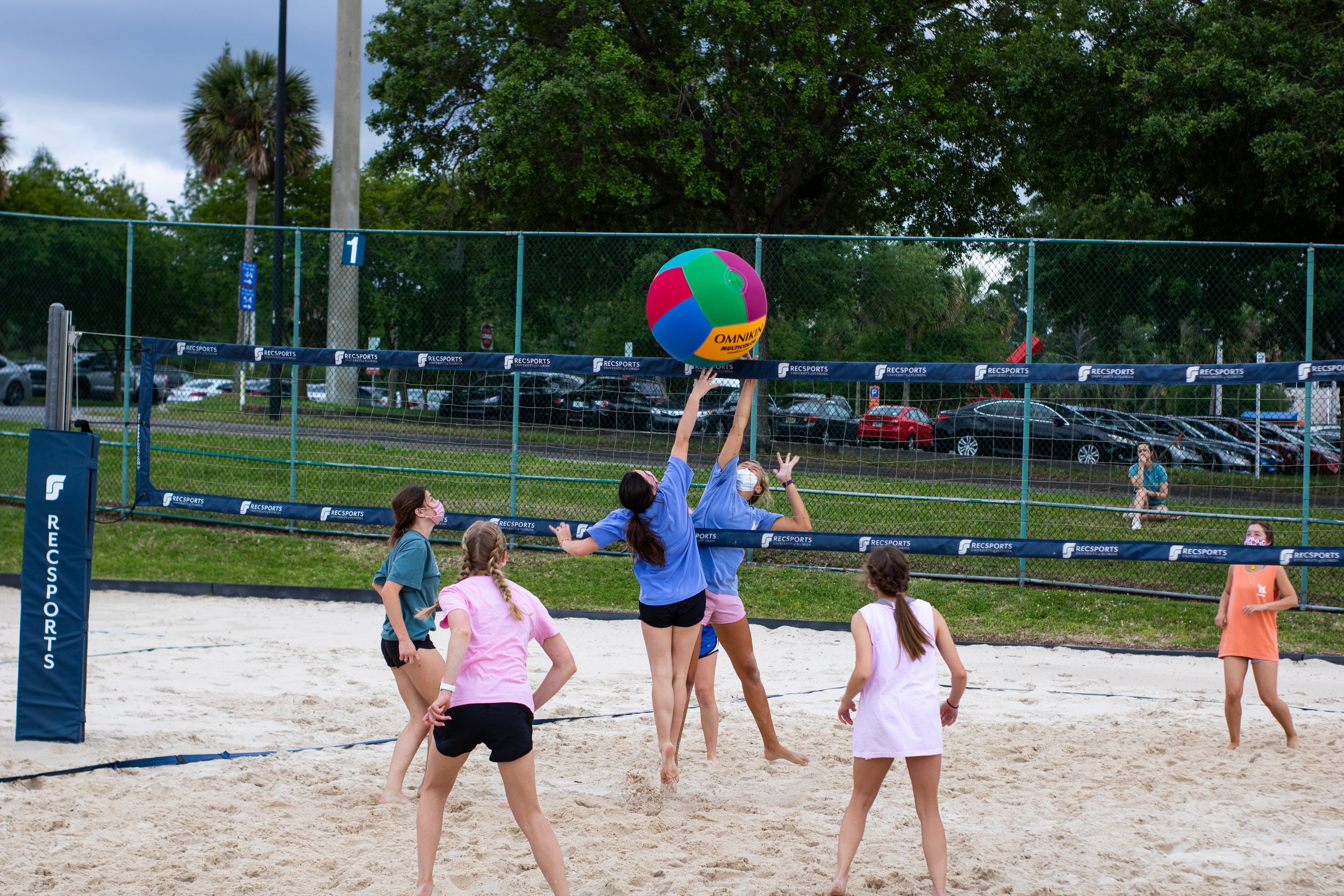 Players reaching for a colorful volleyball during Sugar and Spike
