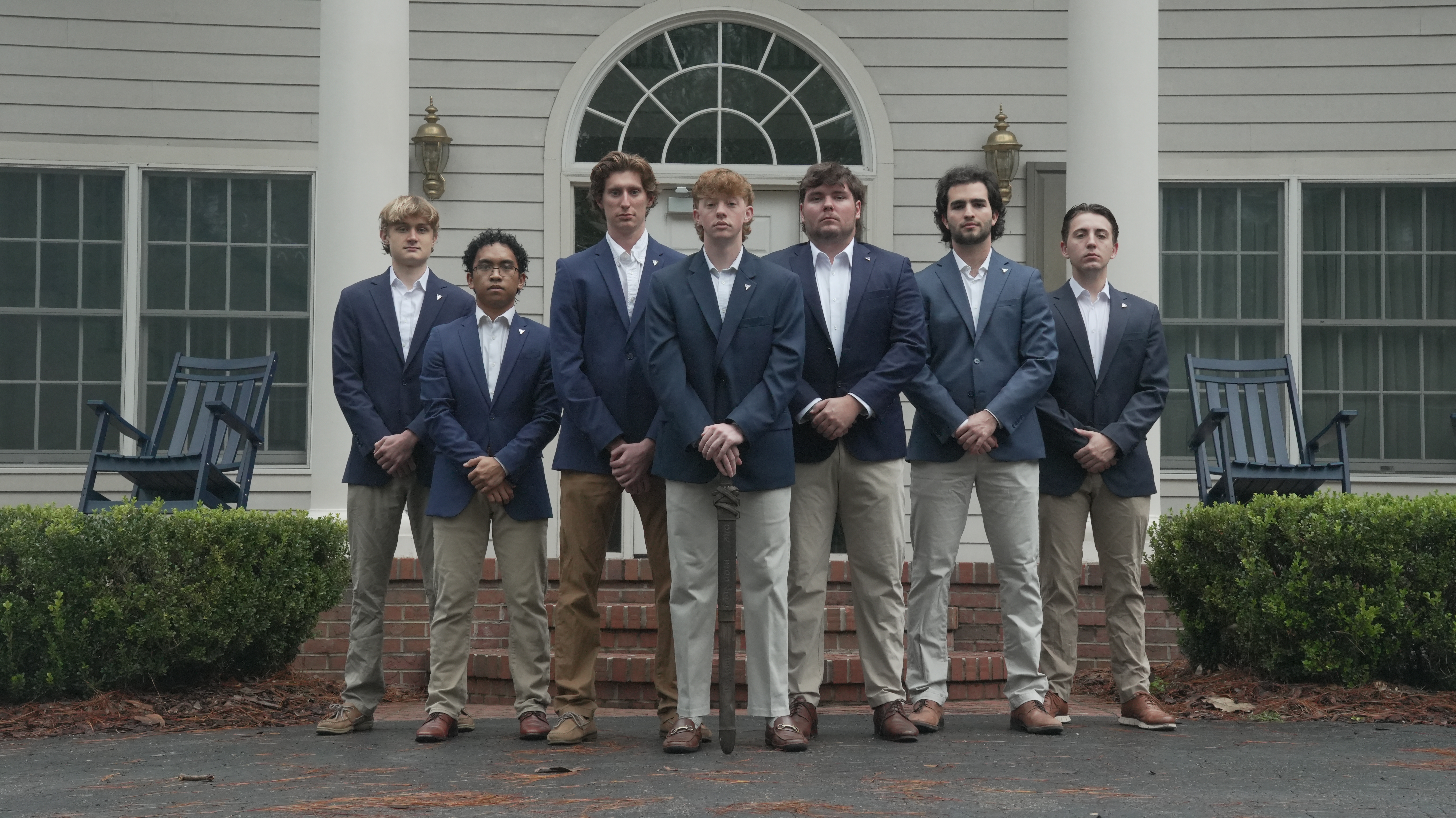 The seven members of the 2026 Officer Corps standing together outside the chapter house